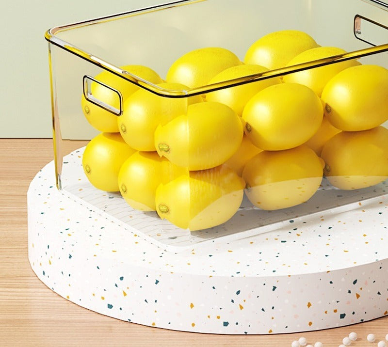 Clear bin filled with lemons on a worktop