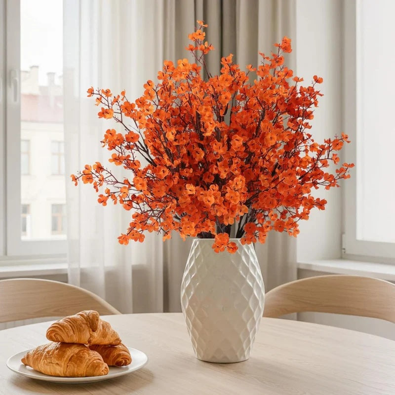Orange artificial gypsophila in a white vase