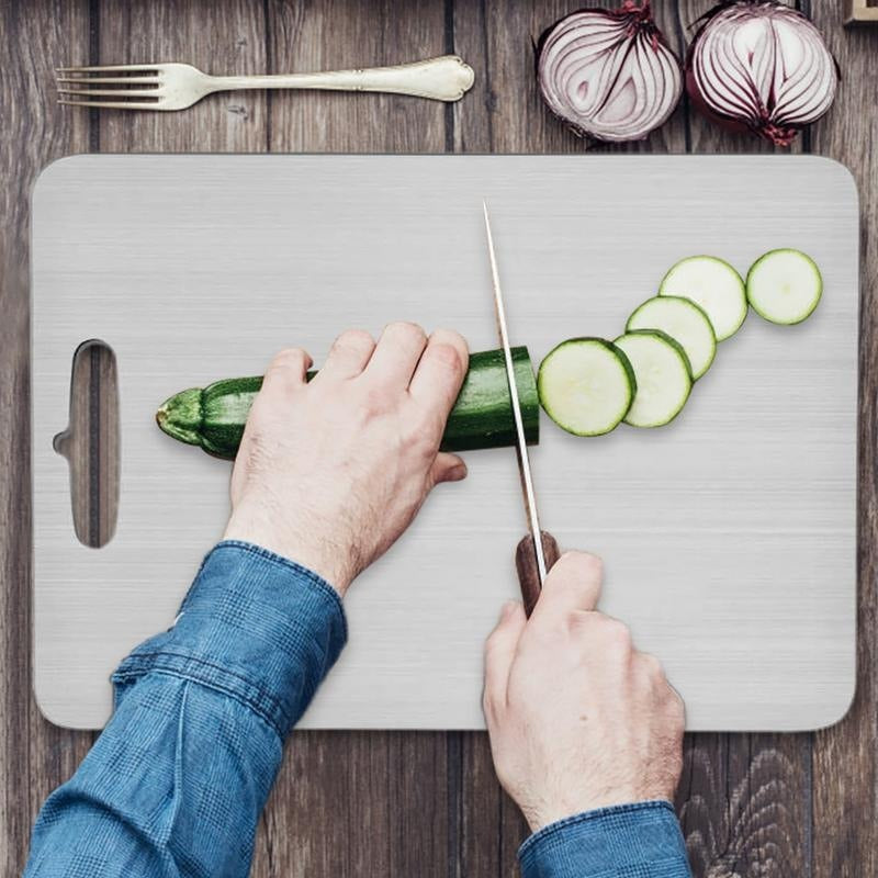 Slicing cucumber on a stainless steel chopping board